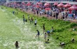 Chinese tourists play by the algae-fille